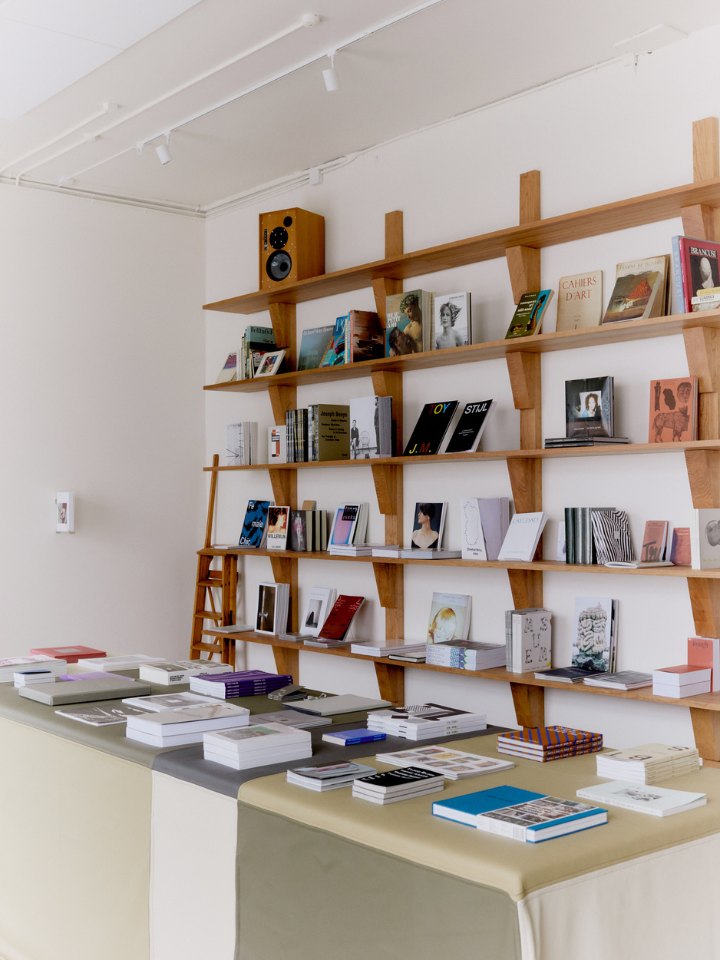 Cherry-wood shelving and the counter stacked with books at Simone